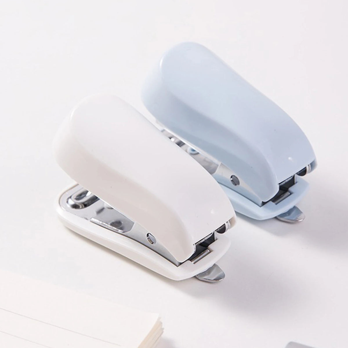 A white and light blue compact mini stapler kit with staples shown in an open view.