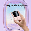 A hand holds a pink power bank with a flashlight, labeled 100%, in an airplane context.