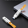A white Kodak metal USB flash drive with a leather lanyard is shown next to a silver laptop.