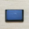 A close-up photo of a blue Ctrl keycap on a keyboard.