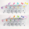 A silver mini shopping cart desktop organizer with rolling wheels and colorful side pockets.