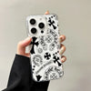 Clear acrylic phone case featuring a black and white design of Chrome Hearts motifs, including horseshoes and floral elements