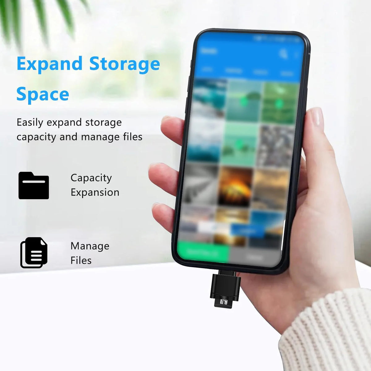 A hand holds a smartphone displaying storage management features, next to a USB-C to SD/TF card reader with a keychain.