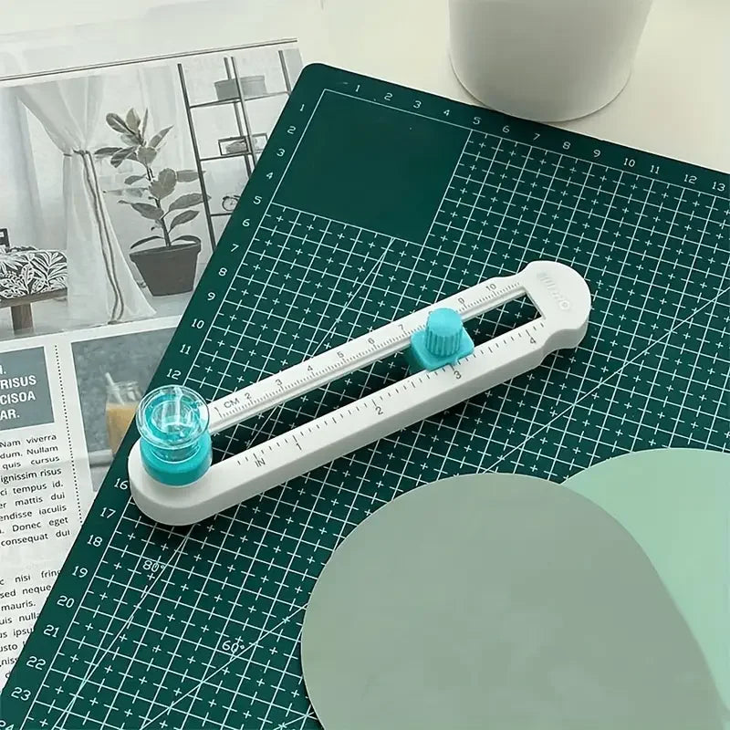 A white adjustable circle cutting tool is shown on a green cutting mat with a ruler and a circular blade.