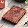 A brown retro PU leather pocket notebook with an embossed circular design resting on a wooden surface.