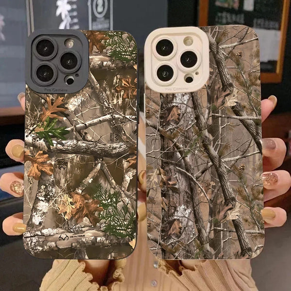 A pair of forest camouflage silicone phone cases for iPhone shown against a dark background.