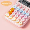 A pink mechanical 12-digit calculator showing various round number keys and a display.