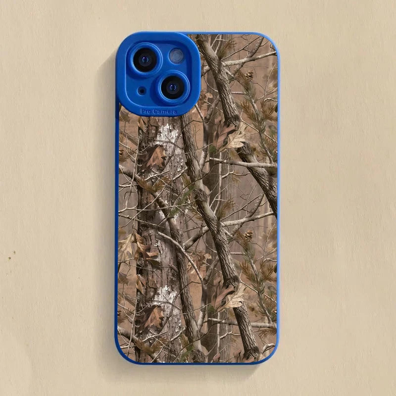 Coque de téléphone en silicone bleu avec motif camouflage de forêt, branches et feuilles.