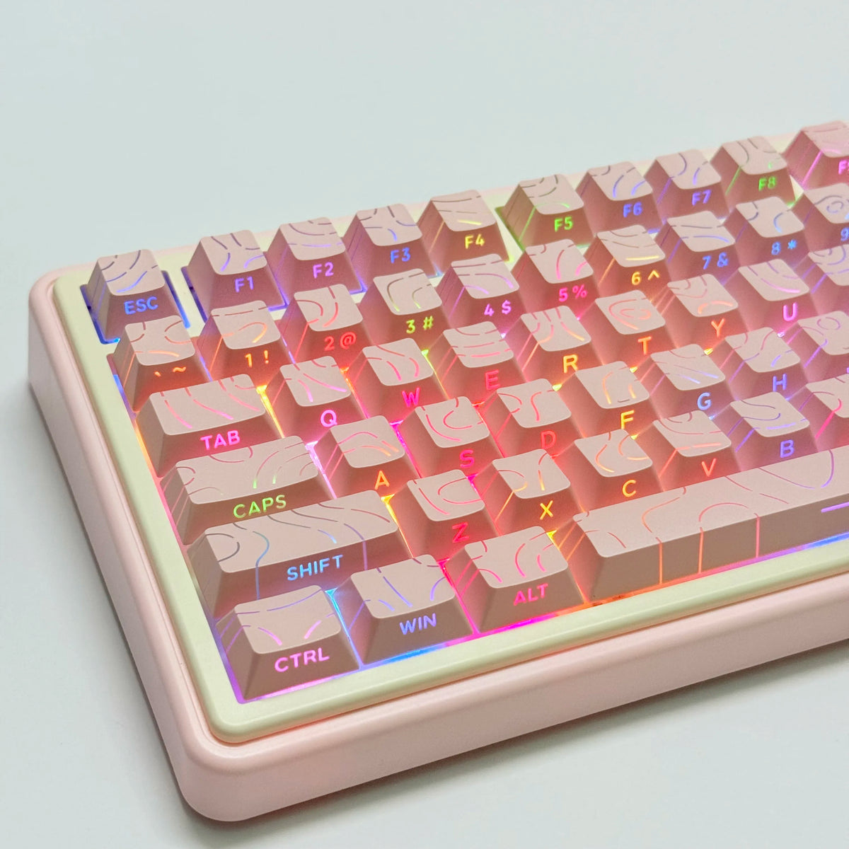 Vista cercana de un teclado mecánico rosa con teclas degradadas y carcasa de color claro.