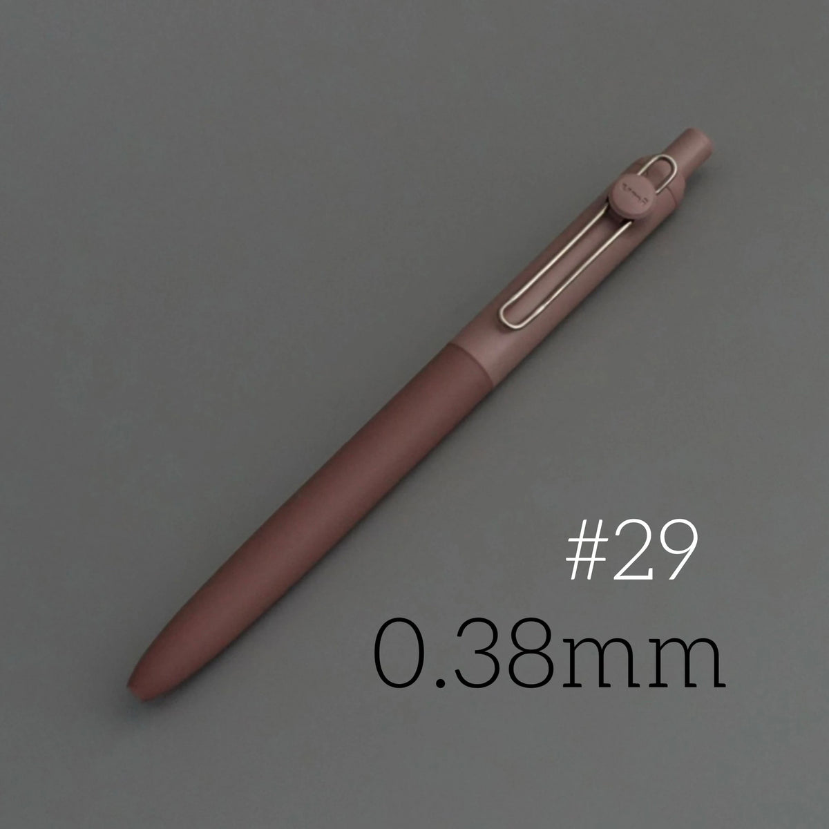 A close-up view of a rose-colored precision gel pen with a metallic tip, labeled #29 and 0.38mm.
