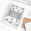 A clear plastic envelope planner with a floral pattern and a gray label is shown on a white surface.