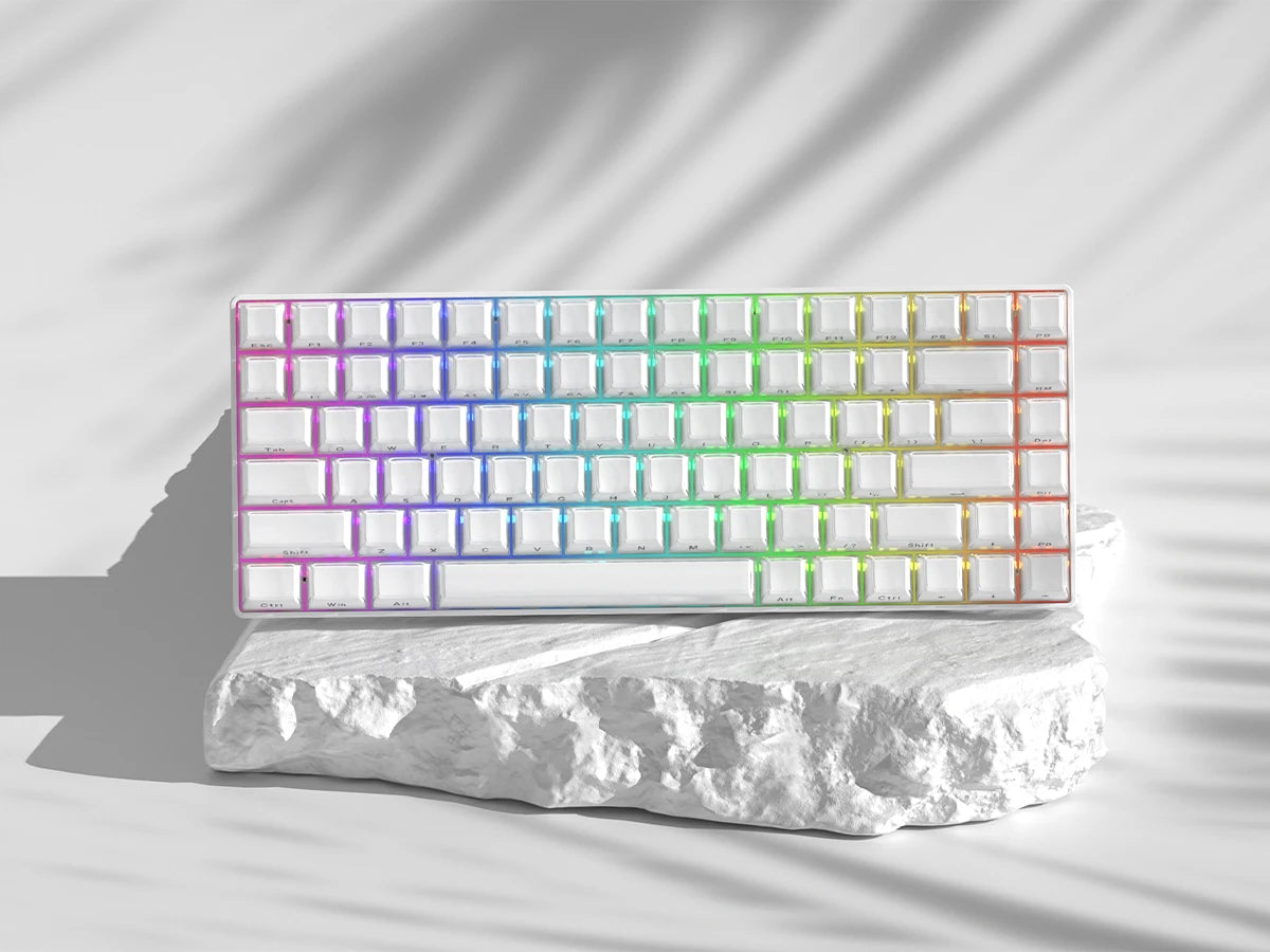 A close-up of a rectangular array of custom printed jelly keycaps in a rainbow gradient on a white surface.