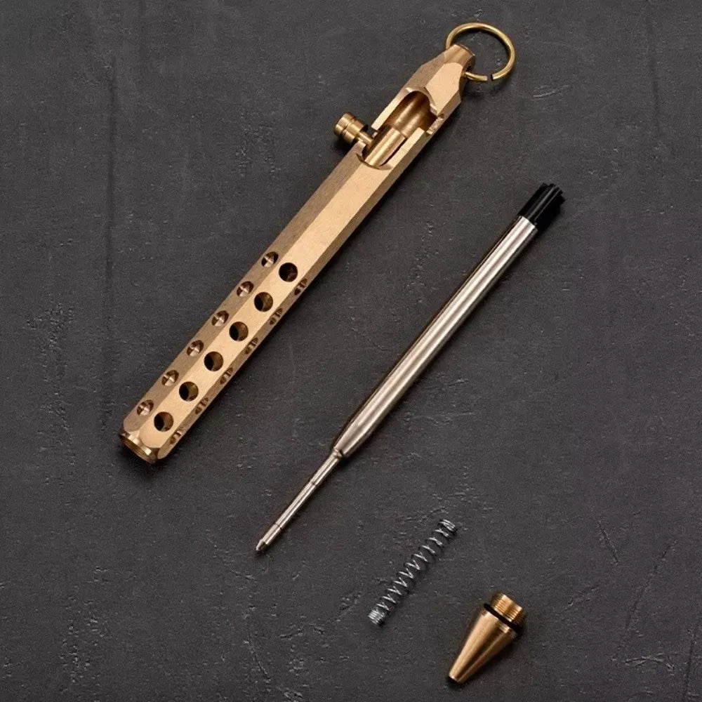 A brass bolt-action ballpoint pen with a gold-colored clip and a silver barrel is shown against a dark background.