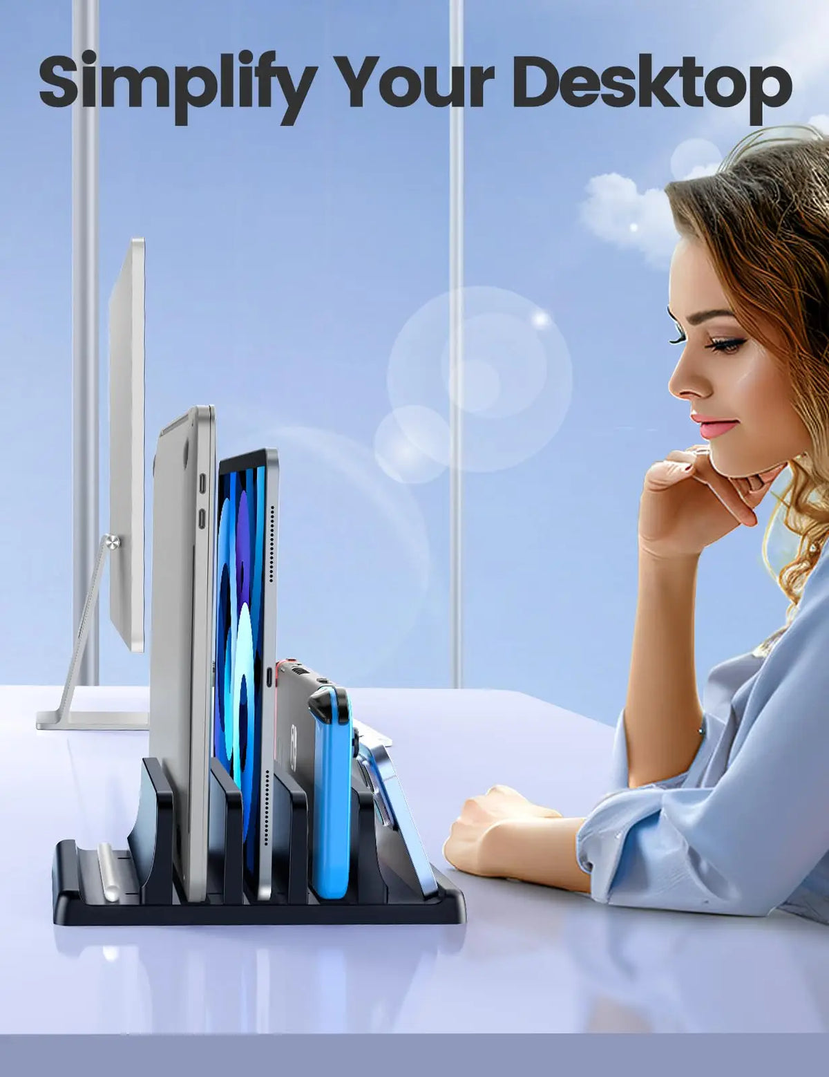 A woman is using a black 3-slot vertical laptop stand organizer on a white desk.