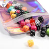 A collection of iridescent self-sealing jewelry pouches in various colors and shapes displayed on a translucent background.