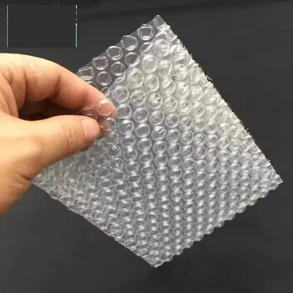 Eine Hand hält eine klare Plastik-Luftblasen-Versandtasche mit einem Diamantmuster.