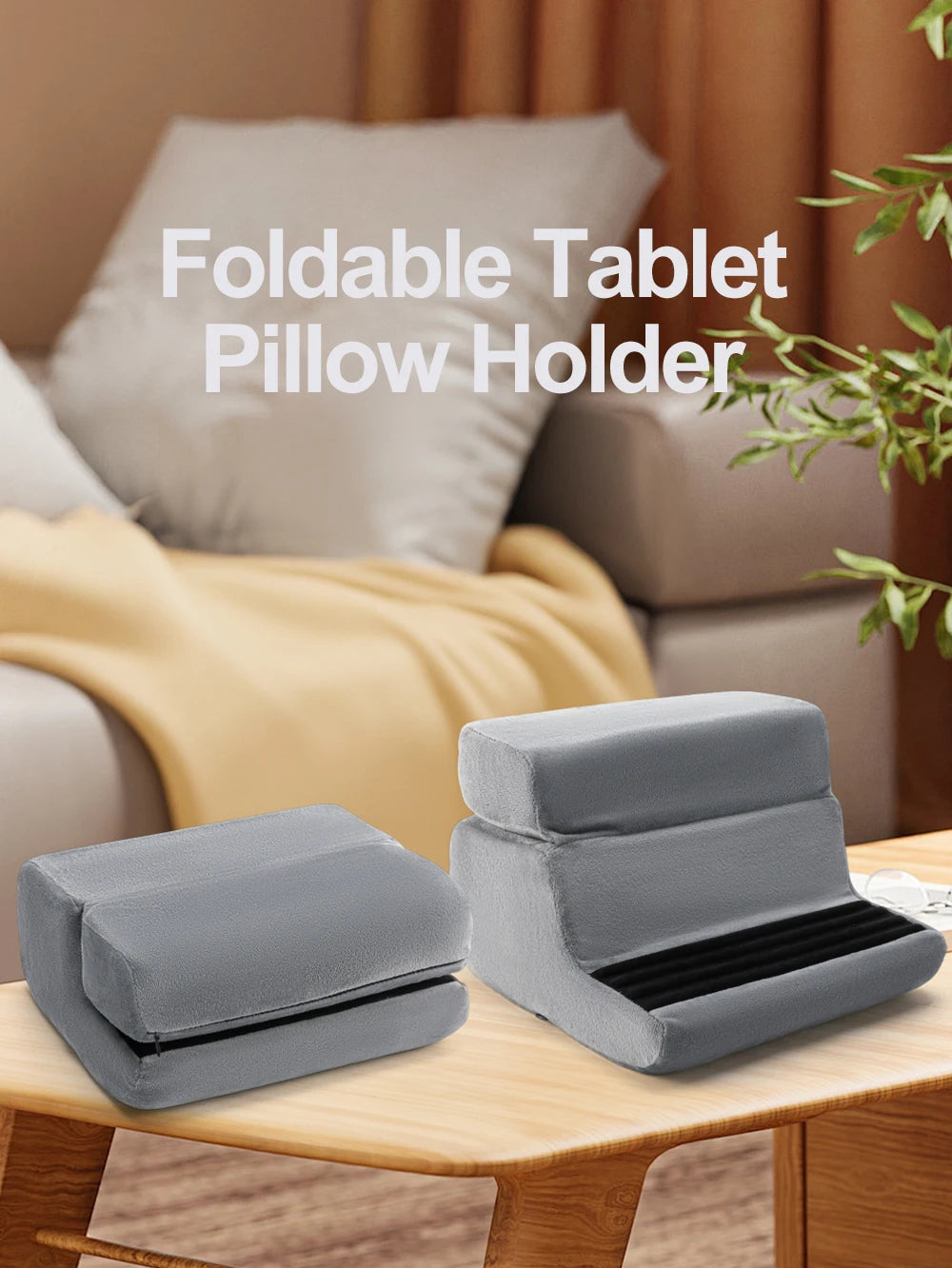 A gray foldable tablet pillow holder is shown resting on a wooden surface.
