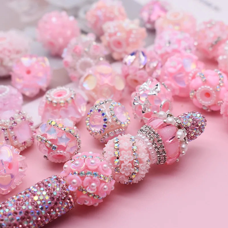 A close-up of pink and iridescent acrylic flower beads used for jewelry making.
