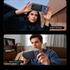 A woman holds a dark smartphone with a clear magnetic case, demonstrating Snap & Tap Easy.