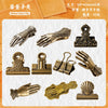 A collection of gilded hand clips in various styles and finishes, including antique brass and gold tones.