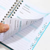A close-up of an A6 password keeper notebook with lined pages and alphabetical tabs for notes.