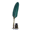 A feather dip pen set featuring a dark teal feather and gold calligraphy nib displayed on a small box.