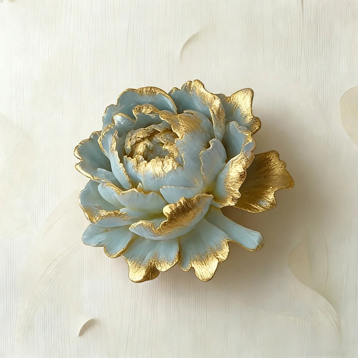 A light blue rose with gold accents is displayed on a white surface.
