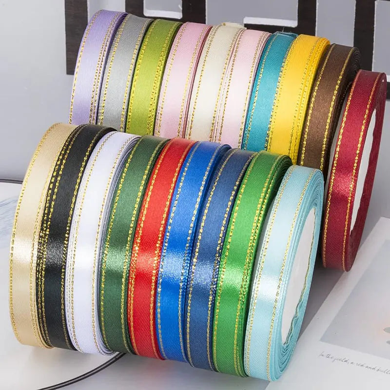 A collection of gold edge satin ribbons in various colors including green, pink, yellow, blue, and red.