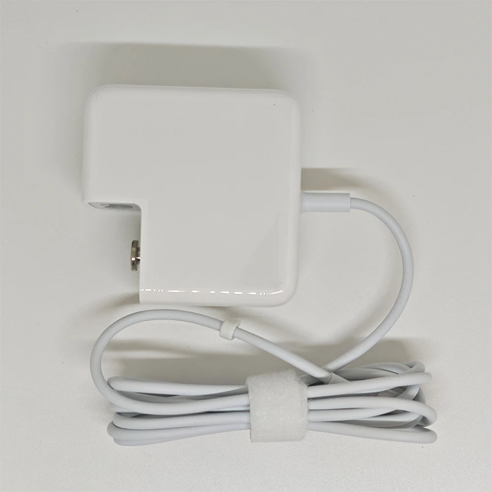 A white universal laptop charger for a MacBook Air with an attached cord.