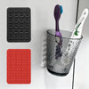A set of silicone suction cups in black and red, along with a purple silicone tool and a clear glass container.