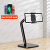 A black adjustable multi-angle stand for tablets and phones shown on a wooden surface.
