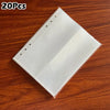 A stack of 20 transparent photo card binder sleeves lying on a wooden surface.