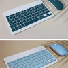 Weiße Mini-Bluetooth-Tastatur und Maus-Kombination mit einer türkisfarbenen Maus daneben.