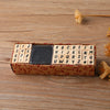 A wooden stamp seal set with numbered and alphabetical characters is displayed on a wooden surface.