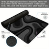 Black abstract art desk mat with a non-slip rubber base showing features like high grip and anti-abrasion