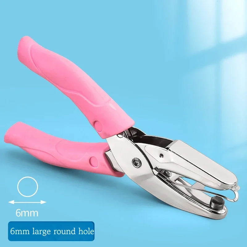 Pink handheld metal puncher with a large round hole for crafting