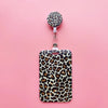 A leopard print ID holder attached to a keychain on a pink background.