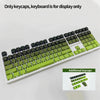 A close-up view of a white keyboard featuring green and black keycaps, with additional keycaps displayed below.