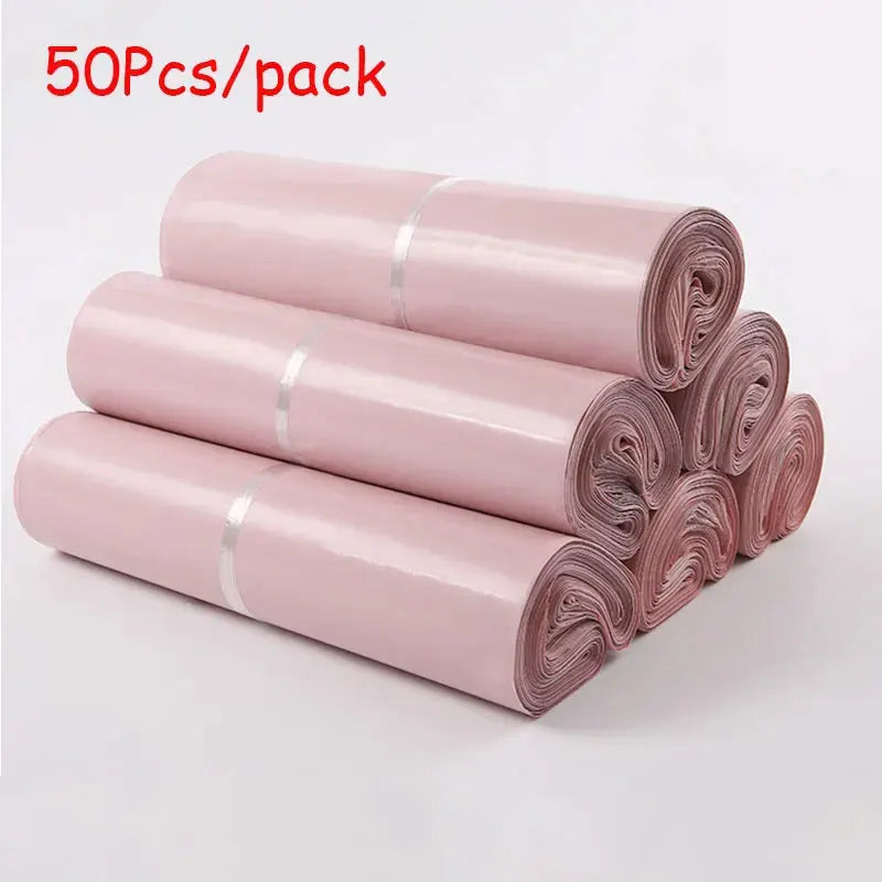 A stack of 50 pink waterproof self-seal poly mail bags rolled up.