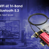 Schwarzer WLAN-Adapter mit Antenne neben einem Computer und einem Monitor.