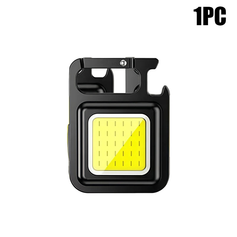 A compact black COB keychain flashlight with a magnetic base and rechargeable battery.