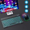 A portable Bluetooth keyboard and mouse set with backlit keys and a sleek design is shown next to a laptop.