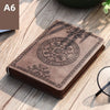 A brown retro PU leather pocket notebook with an embossed circular design resting on a wooden surface.