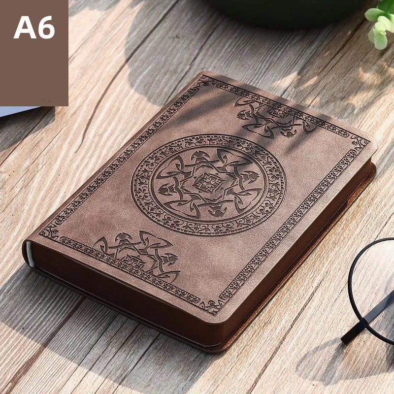A brown retro PU leather pocket notebook with an embossed circular design resting on a wooden surface.