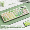 A white and green wireless Bluetooth wired three-mode keyboard with a lime green keycap shown on a desk.