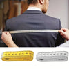 A man is measuring the waist of a suit jacket with two soft flexible measuring tapes, one yellow and one silver.