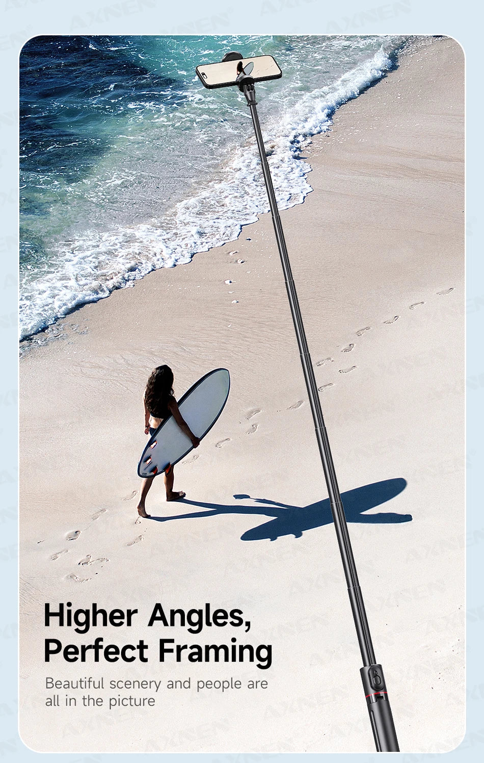A selfie stick is positioned on a sandy beach, with a person surfing and the ocean in the background.