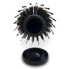 A black hair brush with a hidden compartment for storage.
