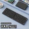 A black foldable Bluetooth keyboard is shown on a light blue surface next to a smartphone and a tablet.