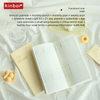 A yellow planner journal is open on a white cloth, surrounded by various planning tools and accessories.